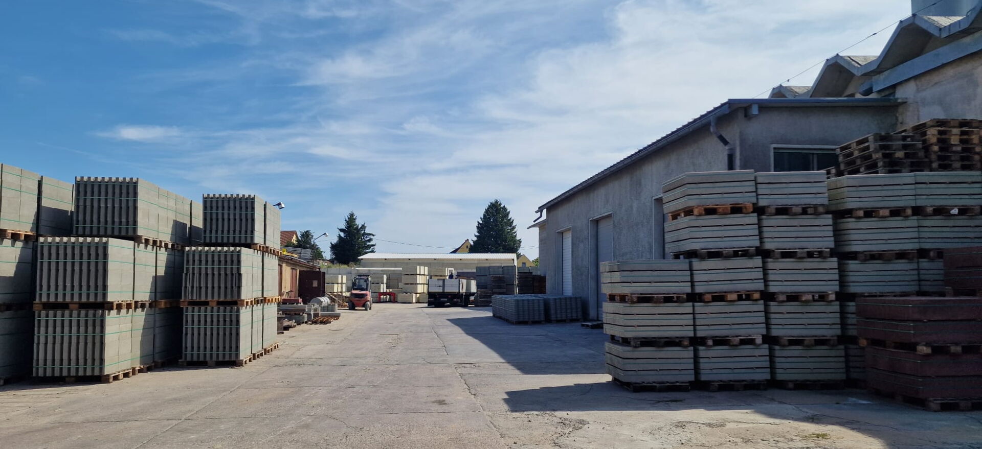  Bauhof mit gestapelten Betonfertigteilen